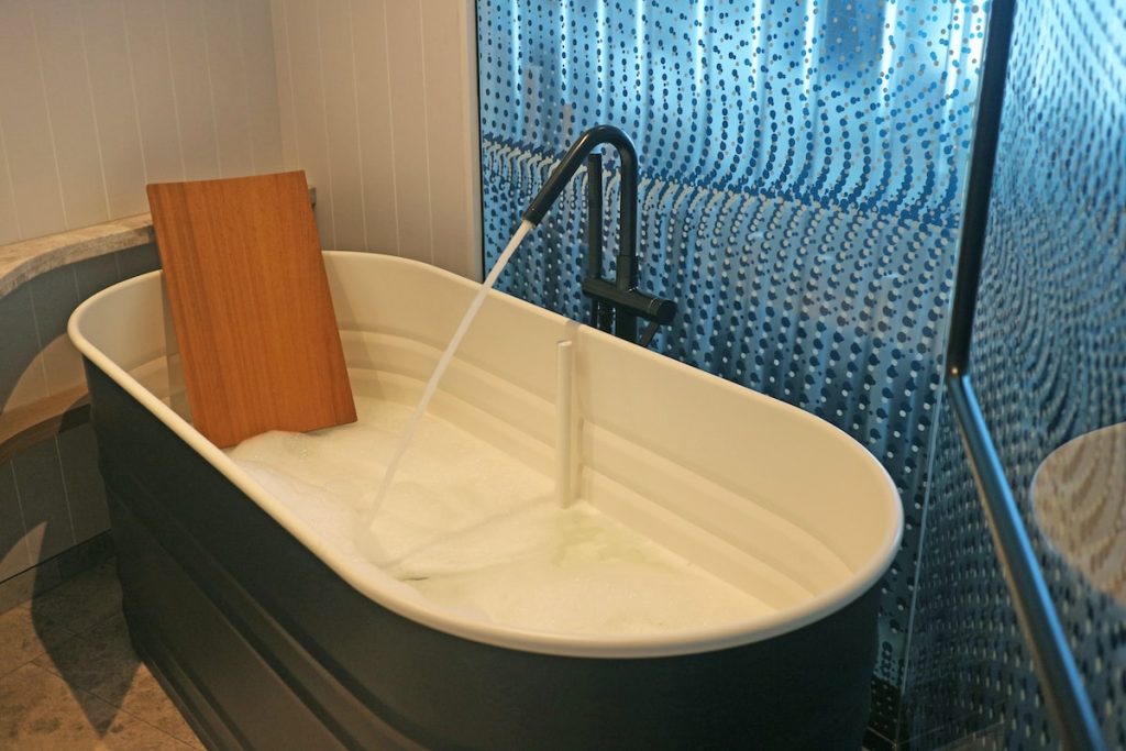a white bath tub sitting next to a walk in shower